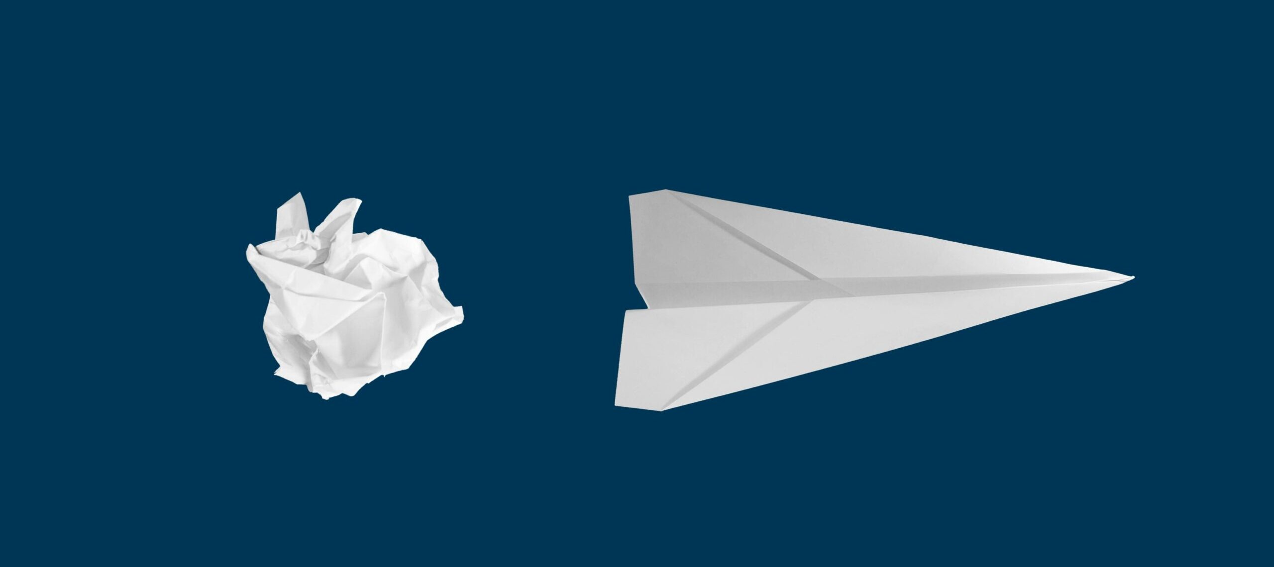 Paper plane and paper ball on blue background